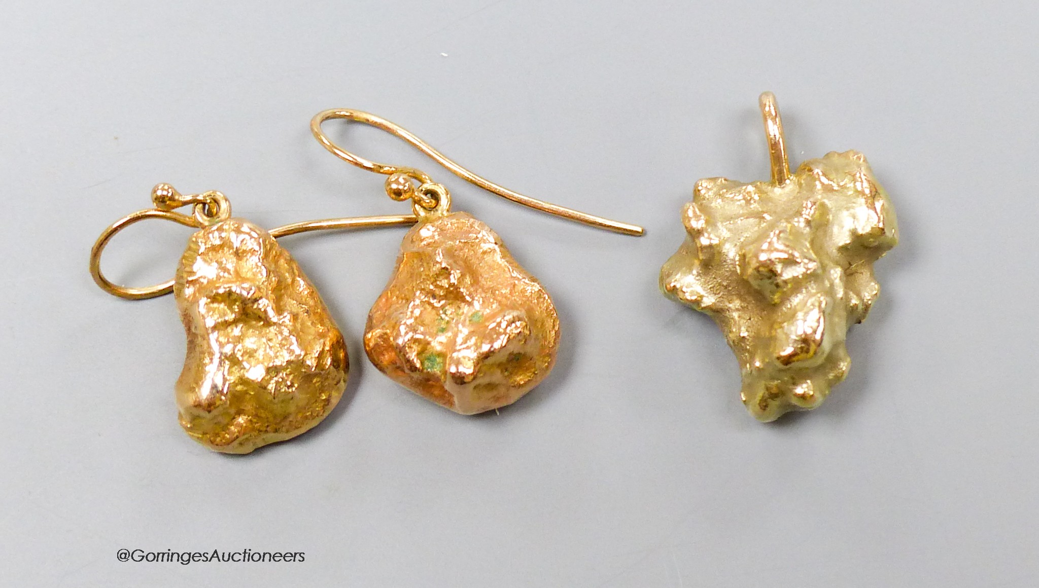 A modern 9ct gold nugget pendant and a pair of similar 9ct earrings, gross 26.1 grams.